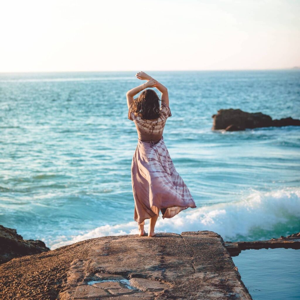 Frau steht am Wasser.