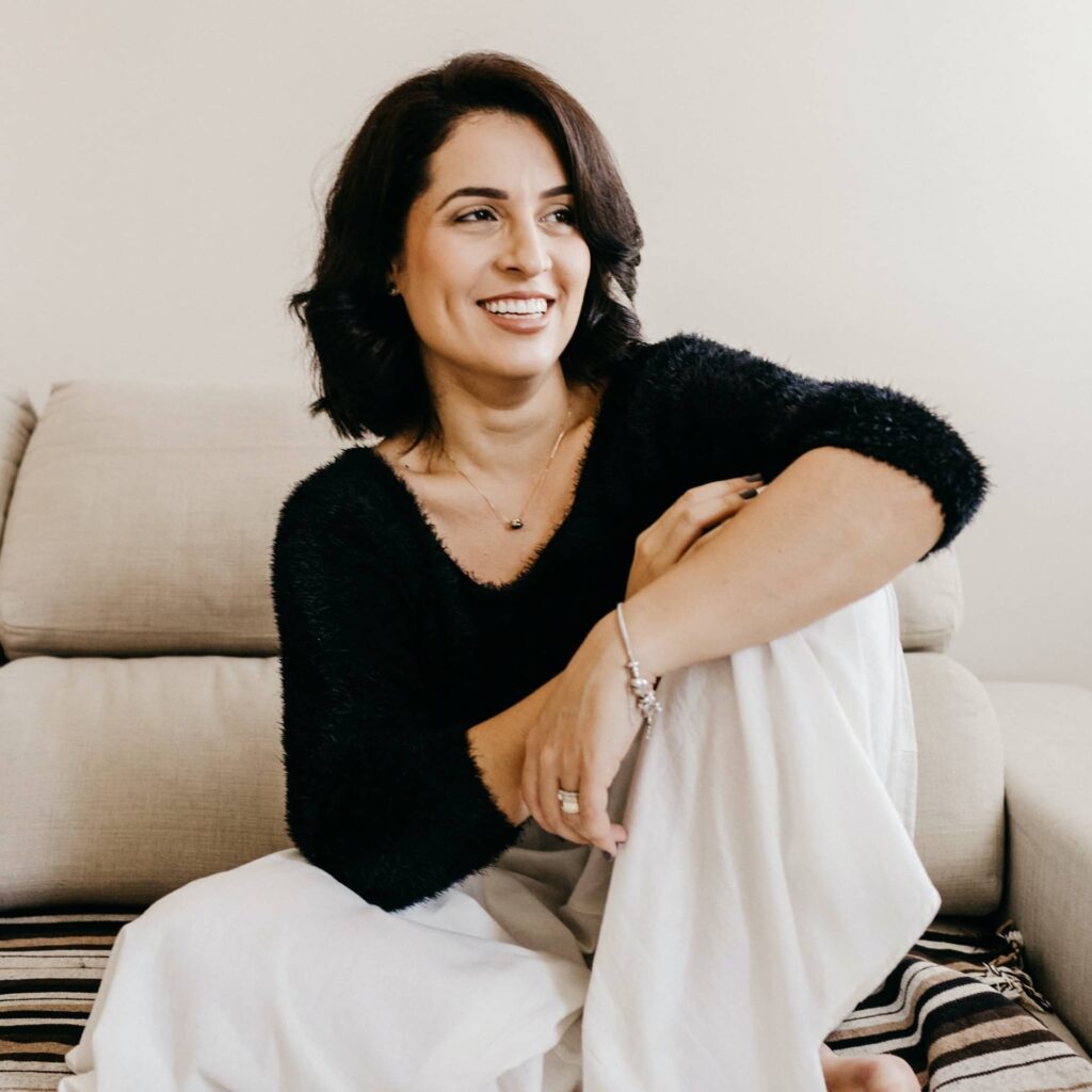 Frau sitzend am Sofa.